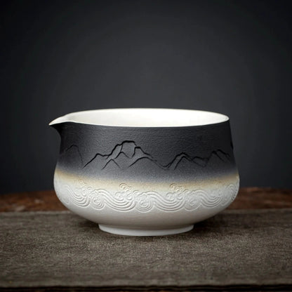 Ceramic bowl with mountain and wave designs on a dark background
