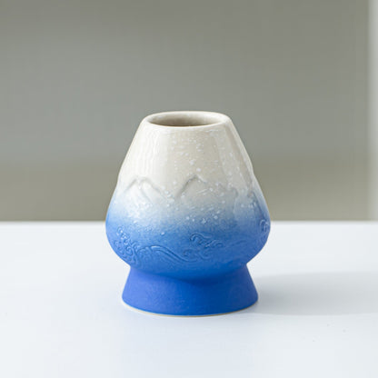 Ceramic vase with gradient from white to blue on a plain background